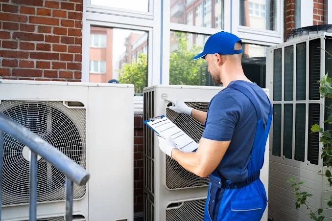 Technician inspecting outdoor cooling units with a clipboard